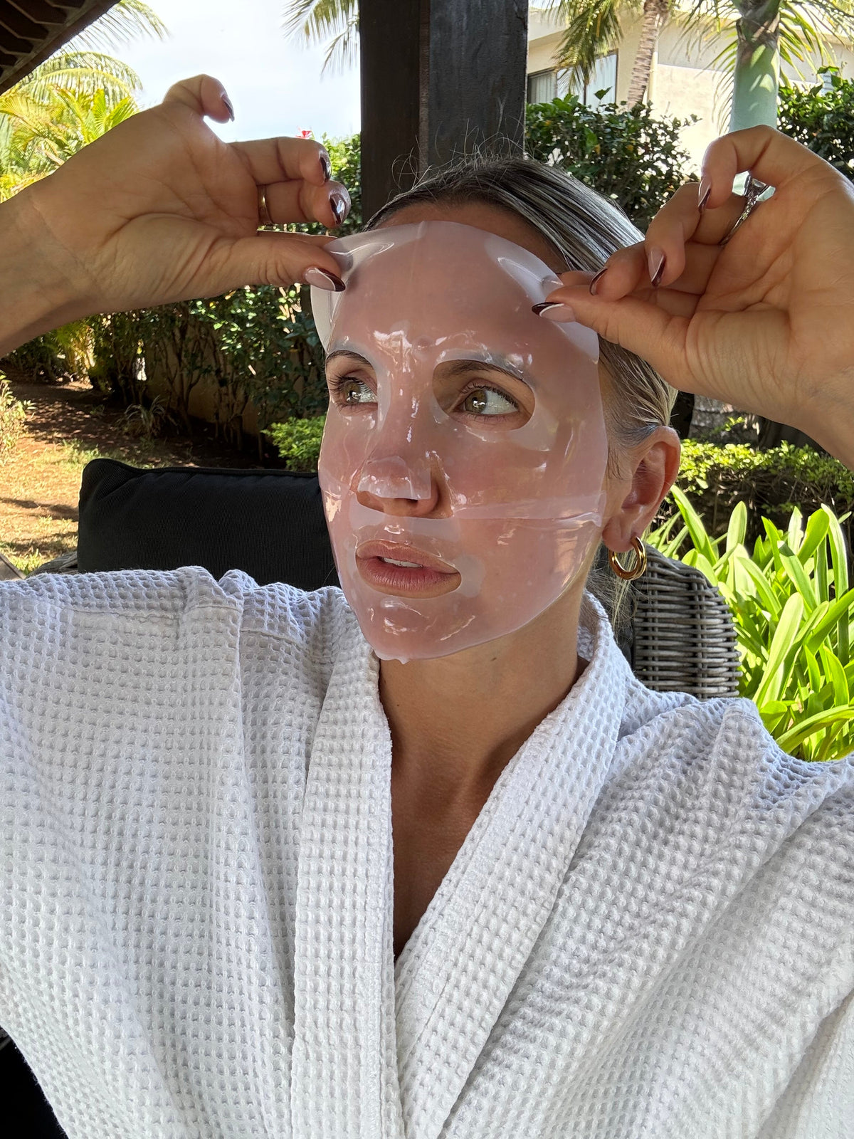 Woman adjusting a translucent facial sheet mask